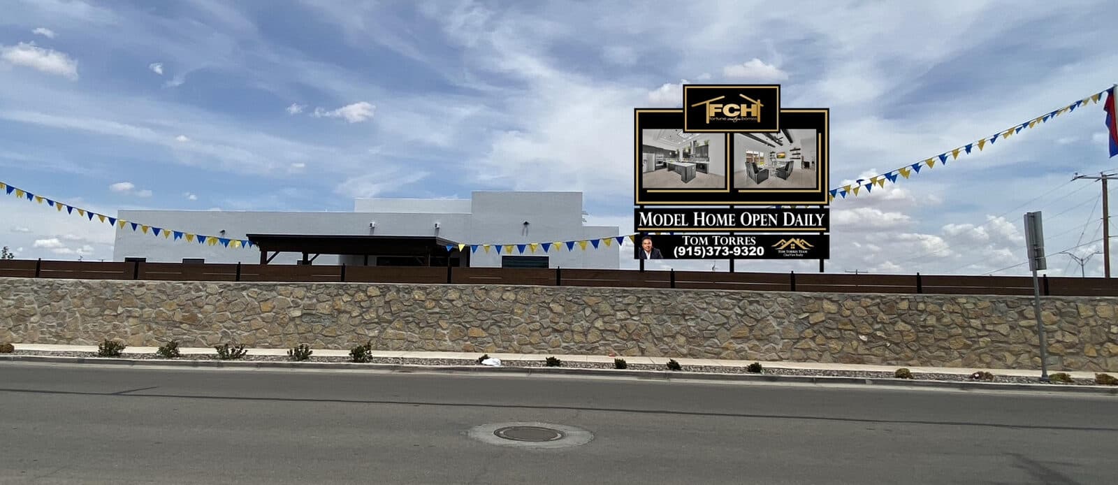 Fortune Custom Homes model home display rising over a community wall