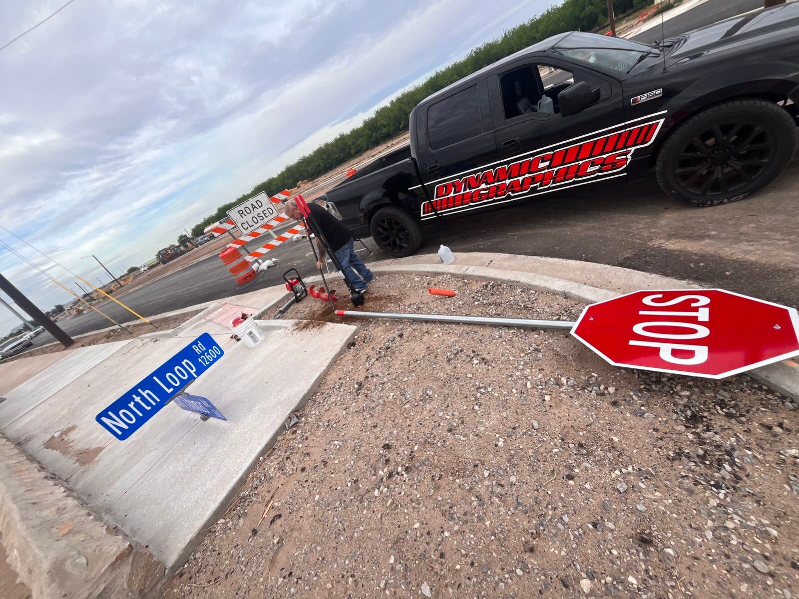 Dynamic Graphics crew installing street signs at a new El Paso intersection, branded work truck behind